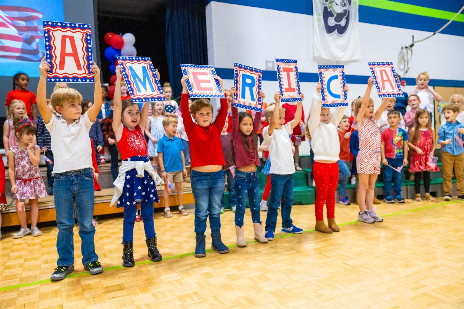 students holding up signs that say AMERICA